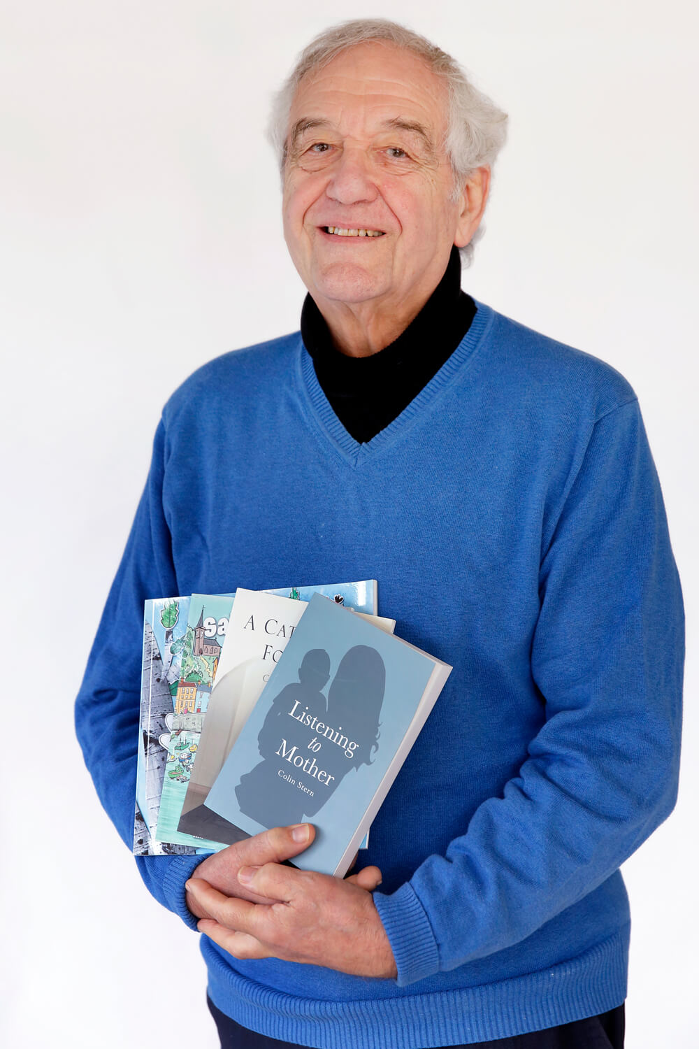 Author Colin Stern holding a selection of his books.